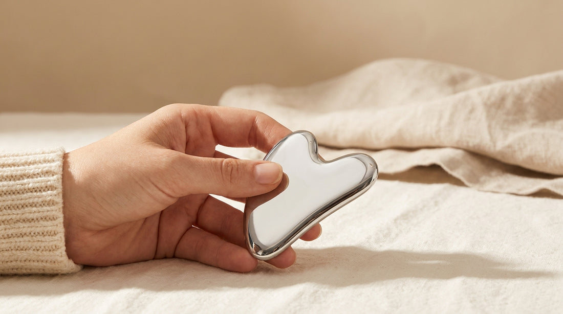 Ръка държи полирана стоманена Gua Sha